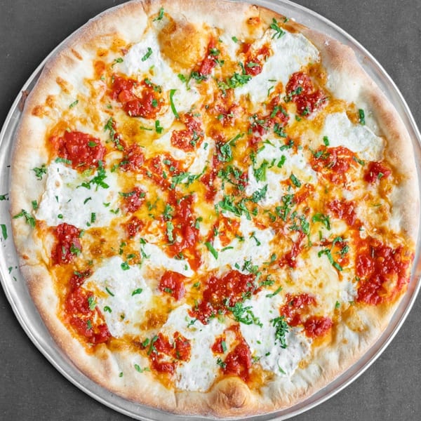 Station Pizza II's white pizza with dollops of red sauce and fresh green herbs.